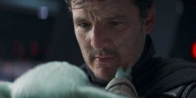Din Djarin (Pedro Pascal) holding Grogu in 'The Mandalorian'