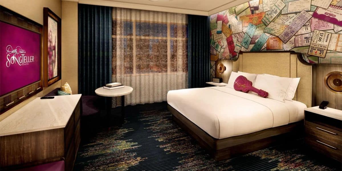 King bed hotel room with rockstar vibes, concert memorabilia art, big window, TV—perfect for music fans on a theme park getaway.