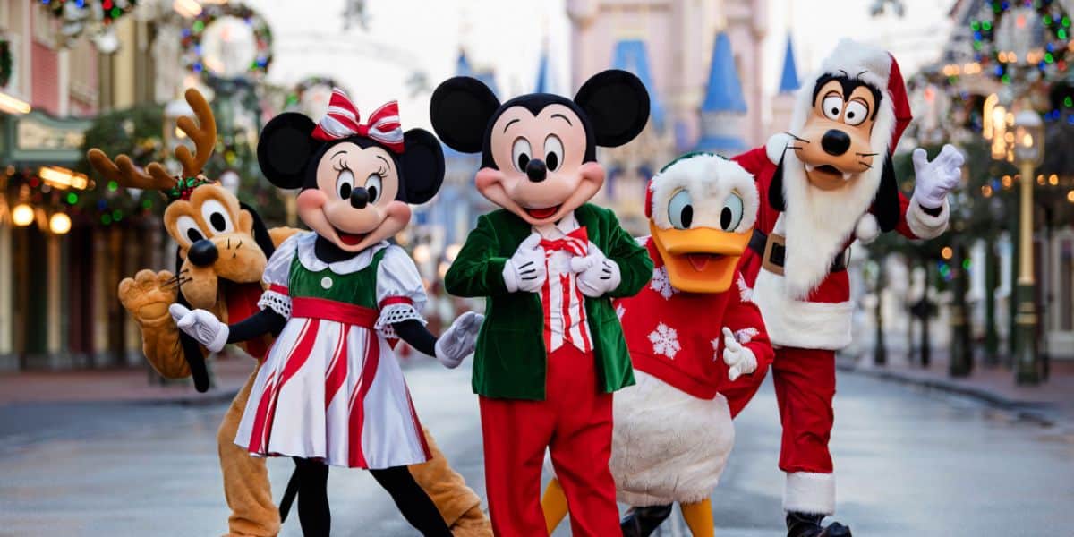 Mickey Mouse and the gang in holiday attire in front of Cinderella Castle at Christmas time