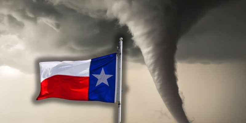 The Texas flag proudly flutters on its pole as a massive tornado twists in the background beneath ominous, stormy skies—evoking the electrifying, adrenaline-packed vibe of a thrill ride at Six Flags Fiesta Texas.