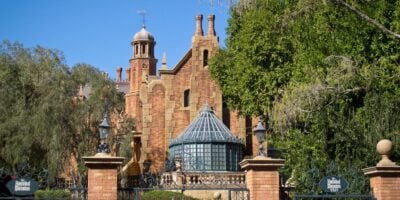 The front of the Haunted Mansion, including its entrance and exit signs, at Magic Kingdom.