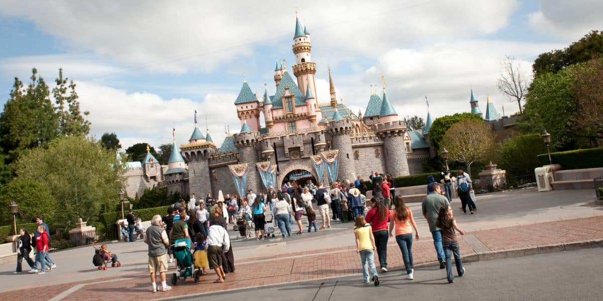 An angled photo of guests walking toward Sleeping Beauty Castle at Disneyland