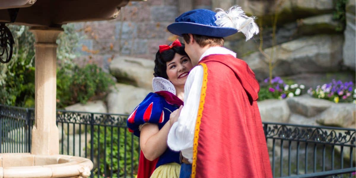 Snow White and Prince Charming pose together in Disney park