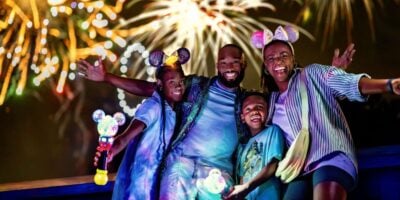 disney world family poses in front of fireworks