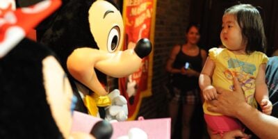 Mickey and Minnie Mouse interact with a little girl in the Town Square Theater at Magic Kingdom.