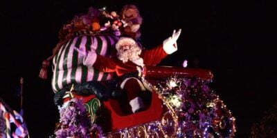Santa Claus on a parade float styled as a sleigh at Disneyland Resort