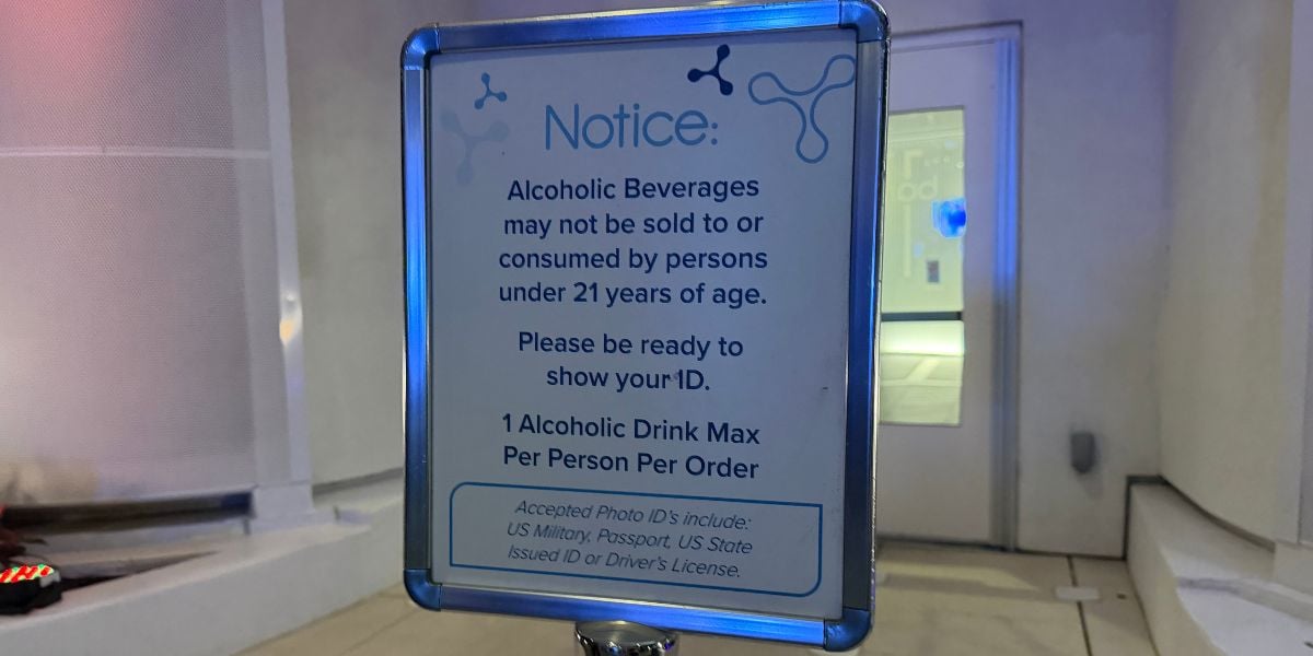 Sign at the theme park stating guests must be 21 or older to purchase alcoholic beverages, valid photo ID is required, and there’s a one drink limit per guest; sign includes a list of acceptable forms of ID.