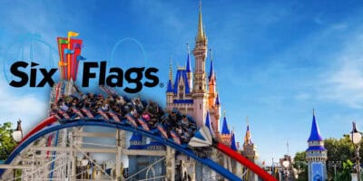Six Flags roller coaster soaring over a magical castle, all set against a bright blue sky.