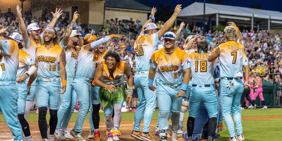 Players from the Golden Eagles baseball team, dressed in vibrant yellow and blue, celebrate an exciting victory on the field as enthusiastic fans cheer them on from the packed stadium stands.