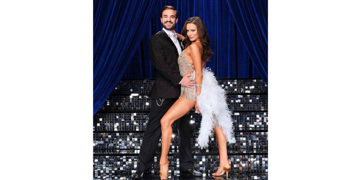 On the sparkling Dancing With The Stars stage, a dashing professional and their celebrity partner wow the audience in dazzling costumes—a sleek black suit and a glittering fringe dress—ready to impress judges like Carrie Ann Inaba with their showstopping routine amid shimmering blue curtains.