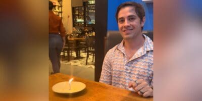 Guest poses with his single candle on an empty plate at a Disney World restaurant