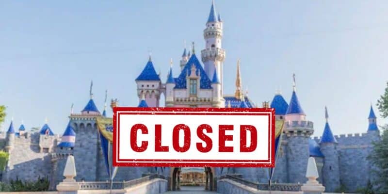 Sleeping Beauty Castle stands at the heart of Disneyland with a bold red “CLOSED” sign displayed out front, signaling the park’s closure; the iconic structure pops against a brilliant blue sky, evoking memories of classic attractions like “it’s a small world.”.