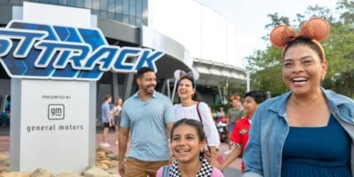 a family happily exits test track in disney world's epcot park