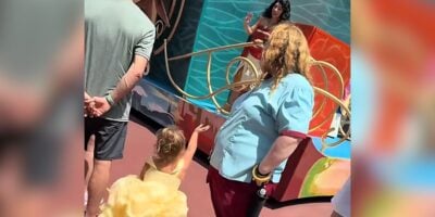 A little girl runs into a parade route to chase Moana at Disney World