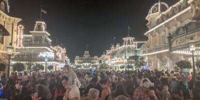 Excited visitors pack Main Street, U.S.A. at night at Magic Kingdom