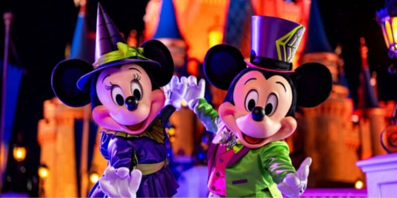 Minnie and Mickey Mouse in Halloween costumes in front of Cinderella Castle at Disney World during Halloween Party