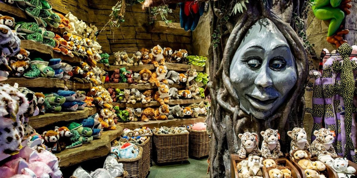 Shelves and baskets overflowing with plush characters surround the Enchanted Tree, its friendly face carved in wood, inviting guests into the whimsical atmosphere of the theme park’s signature toy shop.