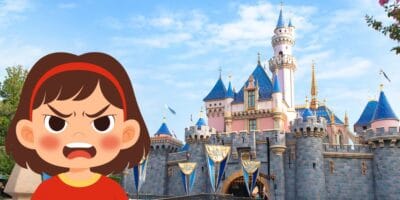 Animated girl looking frustrated in front of Sleeping Beauty Castle with its iconic blue rooftops and clear sky, perfectly capturing that relatable Disneyland moment when the magic meets a busy day and tempers run high—a scene every Disney Parks fan knows all too well.