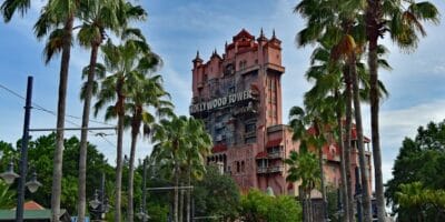 The iconic Hollywood Tower Hotel looms above lush palm trees at Disney’s Hollywood Studios. Inside is the Twilight Zone Tower of Terror