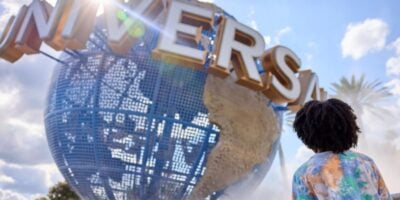 Universal Orlando's iconic spinning globe and a guest standing in front of it