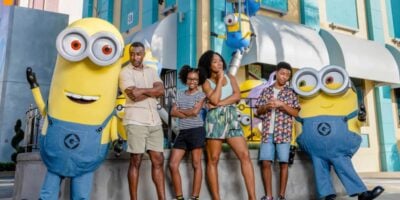 universal orlando guests pose with minions in minions land area inside of universal studios florida
