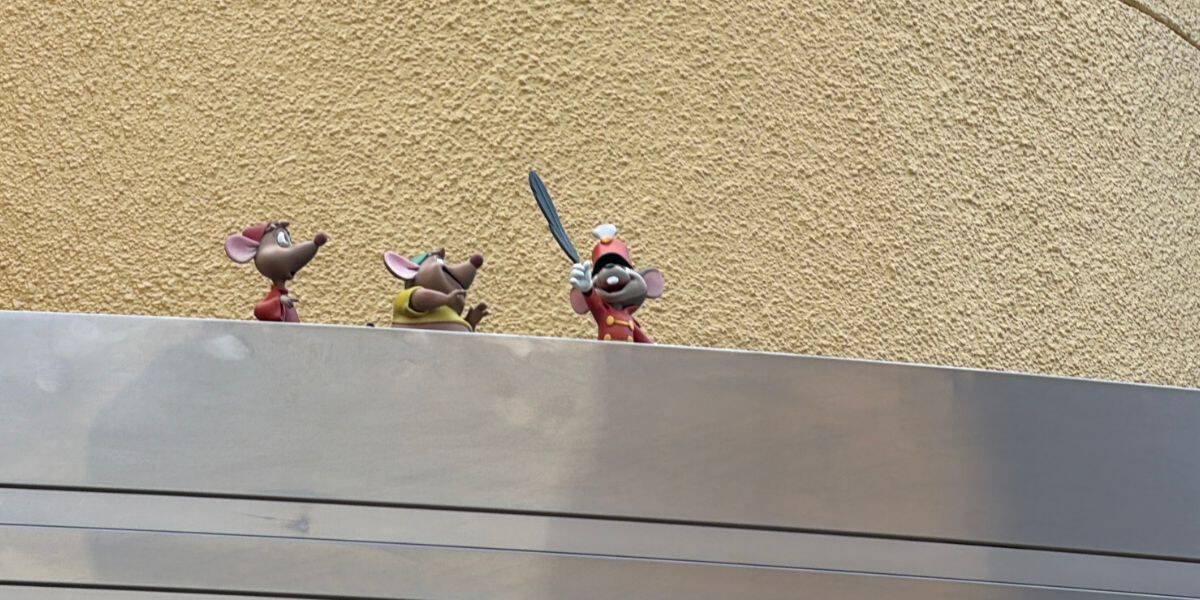 Mickey Mouse and friends appear as lively cartoon characters on a colorful ledge, with Mickey wielding a sword and sporting his signature white hat. Set against a vibrant yellow wall, this scene captures the magic of classic Disney characters—an exciting highlight for fans exploring new attractions at Hollywood Studios.