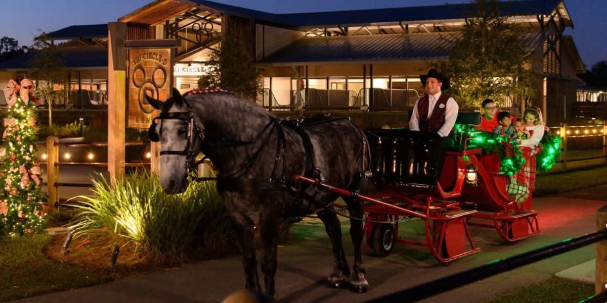 A draft horse pulls a carriage with guests at Tri-Circle-D Ranch at Disney World.