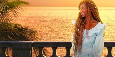 Ariel in her blue dress on the balcony at sunset.