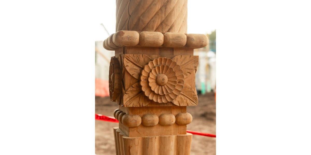Floral-carved wooden pillar in construction zone for disney world's new lakeshore lodge resort