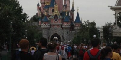 Sleeping Beauty Castle at Disneyland Paris surrounded by park guests.