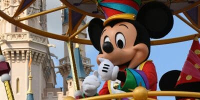 Mickey Mouse waving from a parade float at Disney World.