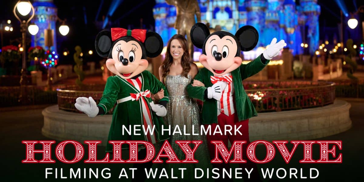 Lacey Chabert posing with Mickey Mouse and Minnie Mouse in front of Cinderella Castle at Walt Disney World for a Hallmark holiday movie.