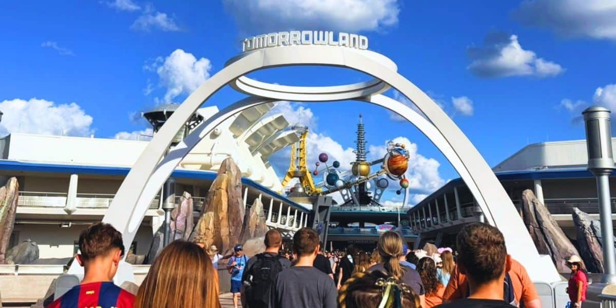 Guests walk through the Tomorrowland entrance at Magic Kingdom in Disney World