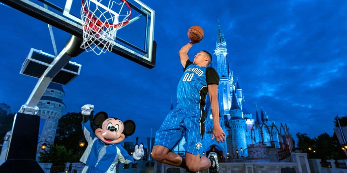 Aaron Gordon dunks a basketball in front of Mickey Mouse and Cinderella Castle at Magic Kingdom in Disney World.