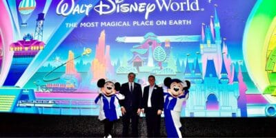 Mickey Mouse and Minnie Mouse posing with two men in suits at Walt Disney World.